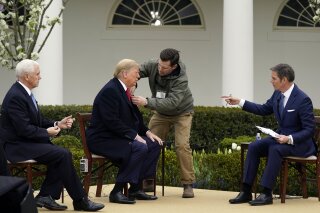 President Donald Trump arrives and speaks with Fox News Channel Anchor Bill Hemmer, as Vice President Mike Pence looks on, during a Fox News Channel virtual town hall, at the White House, Tuesday, March 24, 2020, in Washington. (AP Photo/Evan Vucci)