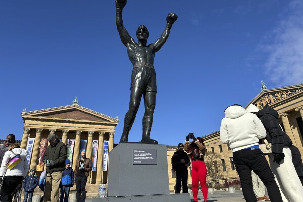 Visitors gather around the Rocky Statue and the “Rocky Steps” during RockyFest 2024 at the Philadelphia Museum of Art, Tuesday, Dec. 3, 2024, in Philadelphia. (AP Photo Tassanee Vejpongsa)