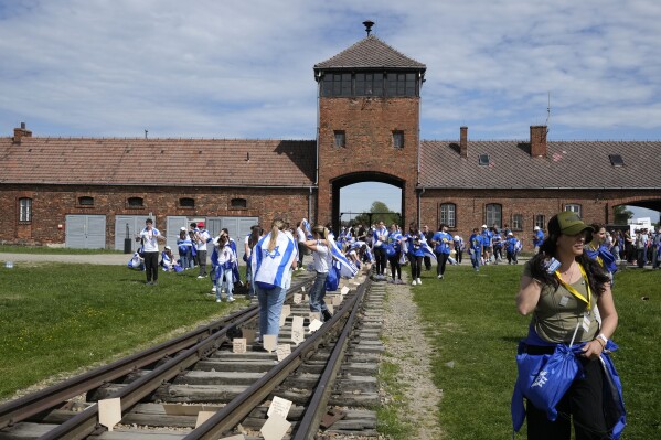 People walk through the former Nazi German death camp of Auschwitz-Birkenau as they attend the annual Holocaust remembrance event, the "March of the Living" in memory of the six million Holocaust victims in Oswiecim, Poland, Monday, May 6, 2024. The event comes amid the dramatic backdrop of the violence of the Israel-Hamas war after the Oct. 7 Hamas attack, the deadliest violence against Jews since the Holocaust, and as pro-Palestinian protests sweep U.S. campuses. (AP Photo/Czarek Sokolowski)