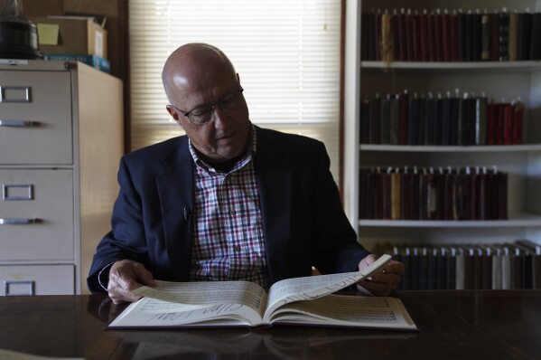 David Ivey, a longtime singer and chair of the Sacred Harp Publishing Company's revision and music committee, looks through "The Sacred Harp," shape-note songbook at the Sacred Harp Publishing Company and Museum in Carrollton, Ga., on Friday, March 21, 2025. (AP Photo/Jessie Wardarski)