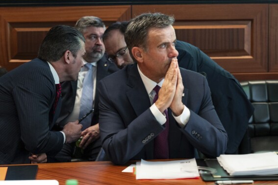 This image released by the White House and digitally altered to diffuse papers by the source for national security reasons, shows CIA Director John Ratcliffe, in foreground seated, as Defense Secretary Pete Hegseth, left, speaks with national security adviser Andy Baker with White House counsel David Warrington seated in background in the Situation Room, Saturday, June 21, 2025, at the White House in Washington. (The White House via AP)