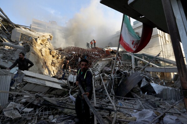 Emergency services work at a building hit by an air strike in Damascus, Syria, Monday, April 1, 2024. An Israeli airstrike that demolished Iran’s consulate in Damascus Monday killed two Iranian generals and five officers, Syrian and Iranian officials said Monday. (AP Photo/Omar Sanadiki)