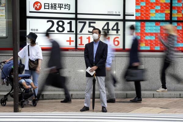 A person wearing a protective mask stands in front of an electronic stock board showing Japan's Nikkei 225 index at a securities firm Friday, Sept. 9, 2022, in Tokyo. Asian benchmarks rose Friday, cheered by gains on Wall Street as comments from the Federal Reserve chairman assured markets on the expected rate rise.(AP Photo/Eugene Hoshiko)