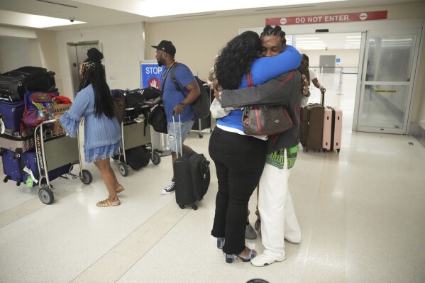 Valerie Laveus greets her brother Reginald Malherbe Daniel as he arrives for the first time to the United States from Haiti at Fort Lauderdale-Hollywood International Airport, in Fort Lauderdale, Fla., Wednesday, Aug. 9, 2023. (AP Photo/Jim Rassol)
