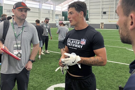 Welsh rugby star Louis Rees-Zammit, center, speaks to NFL scouts following pro day for NFL International Player Pathway prospects held at the University of South Florida on Wednesday, March 20, 2024, in Tampa, Fla. (AP Photo/Rob Maaddi)