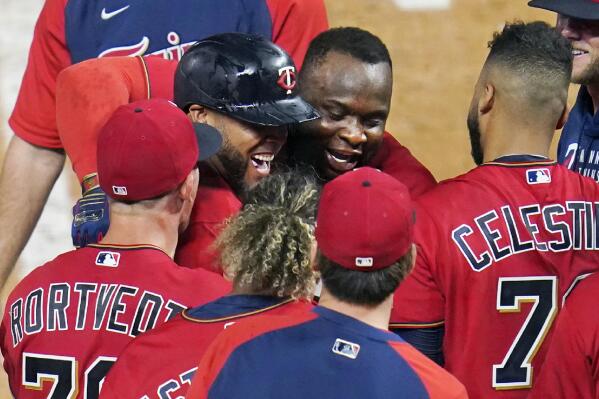 Minnesota Twins' Miguel Sano, center hugs Nelson Cruz after Cruz's two-run home run off New York Yankees relief pitcher Aroldis Chapman during the ninth inning of a baseball game Thursday, June 10, 2021, in Minneapolis. The Twins won 7-5. (AP Photo/Jim Mone)