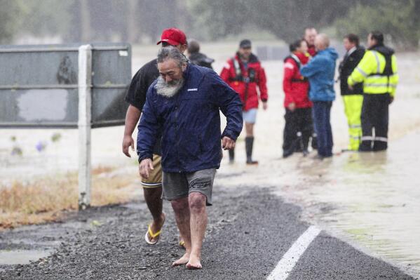 People move away from flood water in Hastings, southeast of Auckland, New Zealand, Tuesday, Feb. 14, 2023. The New Zealand government declared a state of emergency across the country's North Island, which has been battered by Cyclone Gabrielle. (Paul Taylor /Hawkes Bay Today via AP)