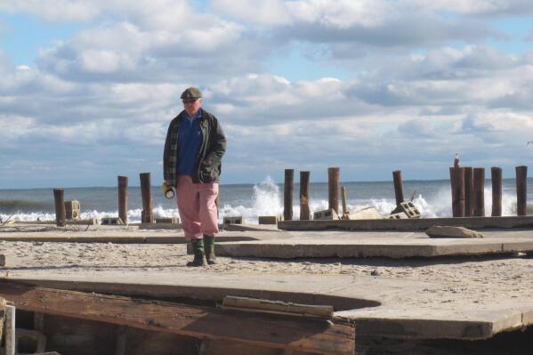 In this Oct. 31, 2012 photo, Peter Green surveys the wreckage of an oceanfront home in Bay Head N.J. two days after Superstorm Sandy hit. Ten years later, government officials and residents say much has been done to prepare for future storms but caution that much more still remains to be done in an era of rising sea levels and a changing climate. (AP Photo/Wayne Parry)