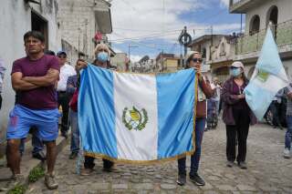 Simpatizantes llevan una bandera de Guatemala mientras escuchan al candidato presidencial Bernardo Arévalo durante un acto de campaña, el domingo 16 de julio de 2023, en Santa María de Jesús, Guatemala. (AP Foto/Moises Castillo)