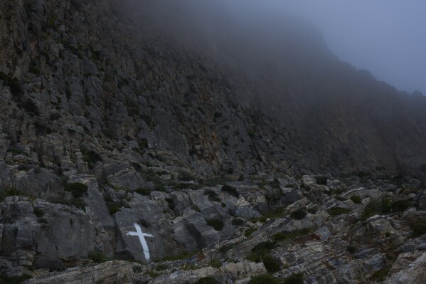 Uma cruz é pintada em um penhasco perto do Mosteiro de Panagia Hozoviotissa na ilha de Amorgos, Grécia, na sexta-feira, 28 de março de 2025. (Foto AP/Petros Giannakouris)