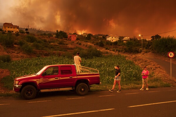 Residents try to reach their houses in Benijos village as a wildfire advances in La Orotava in Tenerife, Canary Islands, Spain, Aug. 19, 2023. (AP Photo/Arturo Rodriguez)