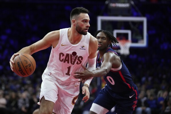 Cleveland Cavaliers' Max Strus, left, tries to get past Philadelphia 76ers' Tyrese Maxey during the first half of an NBA basketball in-season tournament game, Tuesday, Nov. 21, 2023, in Philadelphia. (AP Photo/Matt Slocum)