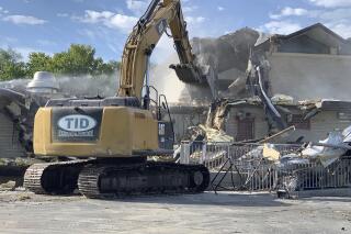 In this Monday, Sept. 13, 2021, photo demolition crews tear down the Wasatch Youth Center, the former long-term, secure lockup for child offenders in Salt Lake City, Utah. (Ben Winslow/KSTU Fox 13 via AP)