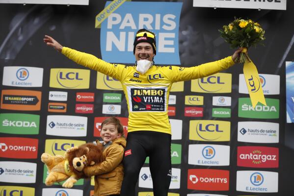 Slovenian rider Primoz Roglic of Jumbo Visma cycling team celebrates on the podium with his son Lev, after winning the Paris-Nice cycling race, in Nice, southern France, Sunday, March, 13, 2022. (AP Photo/Jean Francois Badias)