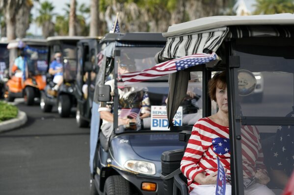 Carts line up before a parade of over 300 golf carts supporting Democratic presidential candidate former Vice President Joe Biden caravanned to the Sumter County Elections office drop off their ballots Wednesday, Oct. 7, 2020, in The Villages, Fla. (AP Photo/John Raoux)