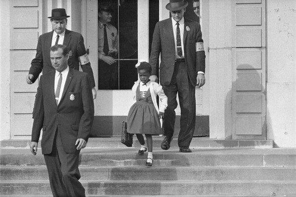 FILE - U.S. Deputy Marshals escort 6-year-old Ruby Bridges from William Frantz Elementary School in New Orleans, in this November 1960, file photo. Seventy years after the Supreme Court's Brown v. Board, America is both more diverse — and more segregated. (AP Photo/File)