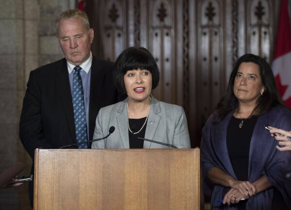 
              Minister of Health Ginette Petitpas Taylor, center, Minister of Justice and Attorney General of Canada Jody Wilson-Raybould, right, and Parliamentary Secretary to the Minister of Justice and Attorney General of Canada and to the Minister of Health Bill Blair, left, speak to reporters during a press conference on Bill C-45, the Cannabis Act, in the Foyer of the House of Commons on Parliament Hill in Ottawa, Ontario on Wednesday, June 20, 2018. The Canadian government said it will soon announce the date of when cannabis will become legal,  but warns it will remain illegal until then. (Justin Tang/The Canadian Press via AP)
            