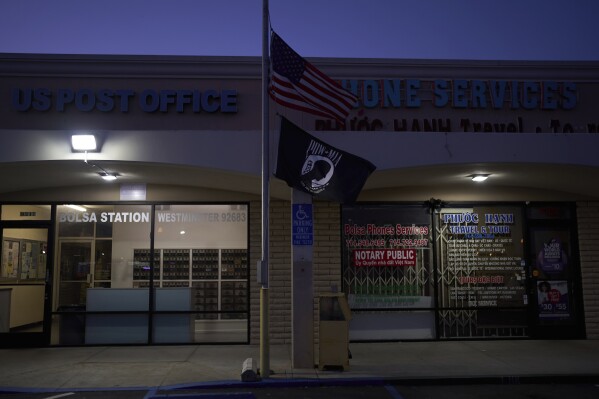 U.S. and POW/MIA flags fly at half-staff outside a post office in the Little Saigon neighborhood of Westminster, Calif., Monday, April 21, 2025. (AP Photo/Jae C. Hong)