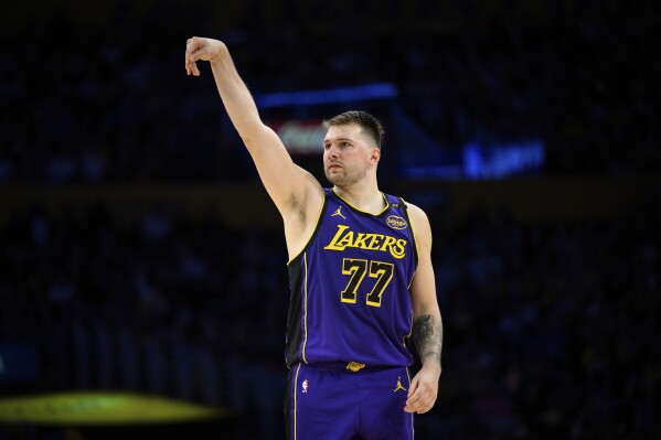 Los Angeles Lakers guard Luka Doncic watches his 3-point shot go in during the second half of an NBA basketball game against the New Orleans Pelicans, Friday, April 4, 2025, in Los Angeles. (AP Photo/William Liang)