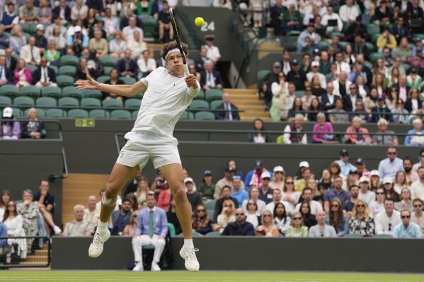 Ben Shelton of the United States plays a backhand return to Denis Shapovalov of Canada during their third round match at the Wimbledon tennis championships in London, Saturday, July 6, 2024. (AP Photo/Alberto Pezzali)