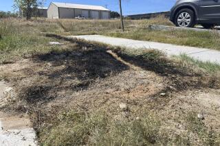 This Sept. 24, 2021 photo provided by Jason Allen and KTVT, shows the spot in Fort Worth, Texas, where a dumpster was on fire that had dismembered bodies inside. Police said the bodies appeared to be those of a man, a teen girl or adult woman, and a child. As of Monday, Sept. 27, 2021, authorities had identified only the man. Police have said the identification process has been difficult because of the condition of the bodies. (Jason Allen/KTVT via AP)
