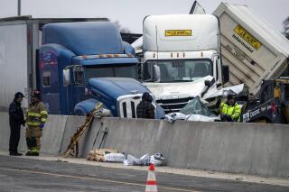FILE - In this Feb. 11, 2021, file photo, emergency personnel cleanup after a massive pileup on Interstate 35 near downtown Fort Worth, Texas. Two of the six people killed in the massive crash involving about 130 vehicles on the icy Texas interstate were fatally struck after getting out of their vehicles, the National Transportation Safety Board reported Wednesday, April 21, 2021. (Yffy Yossifor/Star-Telegram via AP, File)