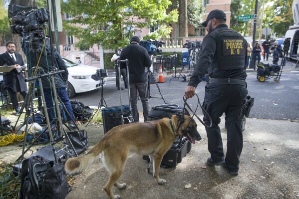 
              An officer with the Uniform Division of the United States Secret Service uses his dog to search a checkpoint near the home of President Barack Obama, Wednesday, Oct. 24, 2018, in Washington. The U.S. Secret Service says agents have intercepted packages containing "possible explosive devices" addressed to former President Barack Obama and Hillary Clinton. (AP Photo/Alex Brandon)
            
