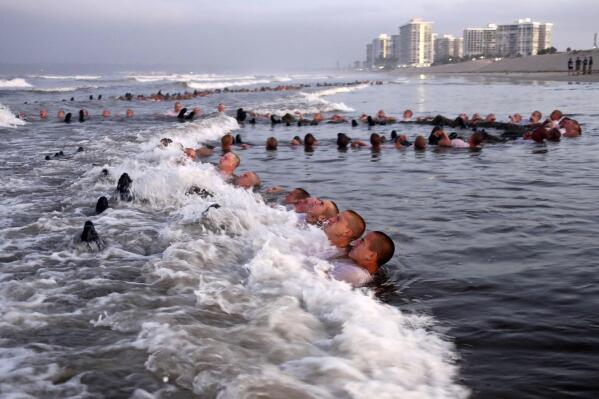 FILE - U.S. Navy SEAL candidates, participate in "surf immersion" during Basic Underwater Demolition/SEAL (BUD/S) training at the Naval Special Warfare (NSW) Center in Coronado, Calif., on May 4, 2020. Navy officials and a new report say the Naval Special Warfare Command has reprimanded three officers in connection with the February 2022 death of SEAL candidate Kyle Mullen, who collapsed and died of acute pneumonia just hours after completing the grueling Hell Week test. (MC1 Anthony Walker/U.S. Navy via AP, File)