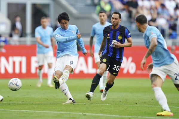 Lazio's Daichi Kamada, left, scores his side's first goal during the Serie A soccer match between Inter and Lazio at the San Siro Stadium in Milan, Italy, Sunday, May 19, 2024. (Spada/LaPresse via AP)