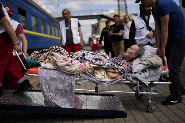 An elderly patient boards a medical evacuation train run by MSF (Doctors Without Borders) at the train station in Pokrovsk, eastern Ukraine, Sunday, May 29, 2022. (AP Photo/Francisco Seco)