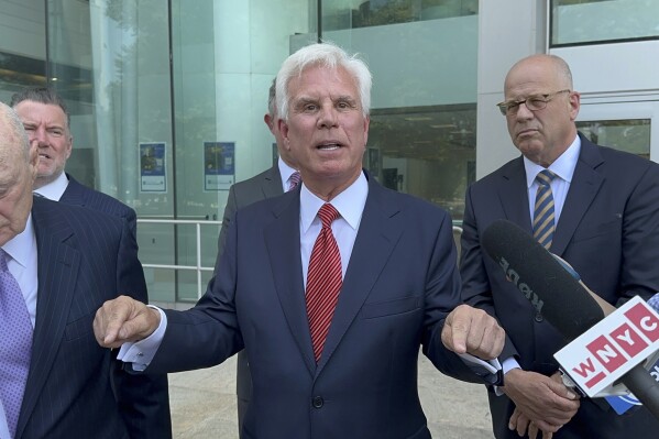Influential Democratic power broker George Norcross, center, speaks outside the justice complex in Trenton, N.J., Monday, June 17, 2024, about being charged with racketeering and other charges in connection with government issued tax credits, saying he wants to go to trial in two weeks and calling New Jersey Attorney General Matt Platkin a “coward.” (AP Photo/Mike Catalini)