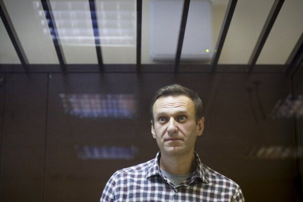 FILE - In this Feb. 20, 2021, file photo, Russian opposition leader Alexei Navalny stands in a cage in the Babuskinsky District Court in Moscow, Russia. Navalny, who is in the third week of a hunger strike, will be admitted to a hospital in another prison, the Russian state penitentiary service said Monday, April 19, after the politician's doctor said he could be near death. (AP Photo/Alexander Zemlianichenko, File)