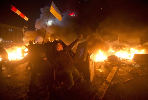FILE - Anti-government protesters clash with riot police in Independence Square in Kyiv, Ukraine, on Feb. 18, 2014. Thousands of police armed with stun grenades and water cannons attacked an opposition camp that was the center of nearly three months of anti-government demonstrations that played out as Russia hosted the 2014 Winter Olympics in Sochi, Russia. (AP Photo/Efrem Lukatsky, File)