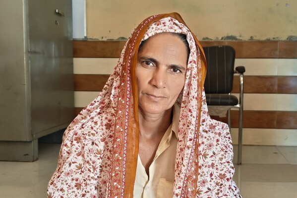 Manju Devi sits in a community center after discussing health issues that she attributed to climate change, in Syaraul village in Uttar Pradesh state, India, Oct. 18, 2023.  (Uzmi Athar via AP)