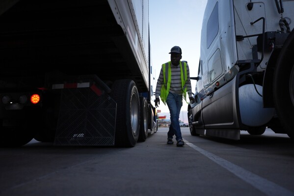 Haitian immigrant Kevenson Jean, a truck driver, checks his truck before a road trip, Tuesday, April 15, 2025, in Panhandle, Texas. (AP Photo/Eric Gay)