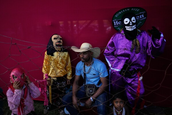 Una familia disfrazada asiste a las Cavalhadas, o Fiesta del Espíritu Santo, en Pirenópolis, estado de Goiás, Brasil, el domingo 8 de junio de 2025. (Foto AP/Eraldo Peres)