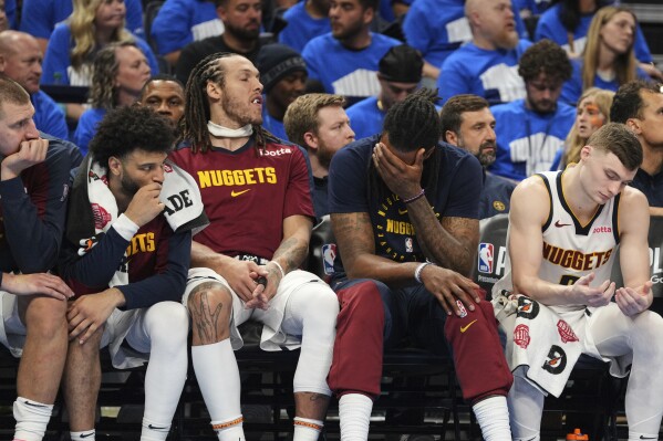 Denver Nuggets' Nikola Jokic, from left, Jamal Murray, Aaron Gordon, DeAndre Jordan and Christian Braun, right, sit on the bench watching play against the Oklahoma City Thunder late in the second half of Game 7 in the Western Conference semifinals of the NBA basketball playoffs, Sunday, May 18, 2025, in Oklahoma City. (AP Photo/Kyle Phillips)