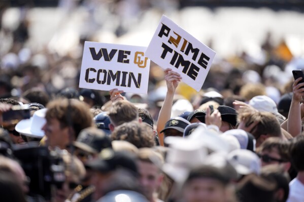 Colorado fans hold up placards as they storm the field after the second half of an NCAA college football game against Nebraska Saturday, Sept. 9, 2023, in Boulder, Colo. (AP Photo/David Zalubowski)