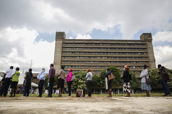 FILE - Kenyans line up to receive a COVID-19 vaccine, at Kenyatta National Hospital in Nairobi, Kenya, Tuesday, April 6, 2021. Thousands of doctors have stayed away from hospitals since last Thursday, March 12, 2024 over poor pay and working conditions, despite a court order calling for talks between the doctors and the Health Ministry. Health Minister Susan Nakhumicha told local television station KTN that she had instructed two top referral hospitals to recruit doctors to replace those taking part in the national strike. An Associated Press journalist confirmed on Thursday morning that emergency services at the Kenyatta national referral hospital in the capital, Nairobi, had resumed. (AP Photo/Brian Inganga, File)