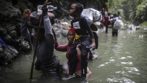 FILE - Haitian migrants wade through water as they cross the Darien Gap from Colombia to Panama in hopes of reaching the U.S., May 9, 2023. Hundreds of thousands of migrants have risked the dangerous trek through the jungle in recent years and the flow this year is on a record pace. (AP Photo/Ivan Valencia, File)