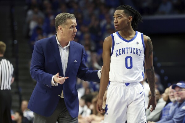 Kentucky's head coach John Calipari, left, talks to Rob Dillingham (0) during the second half of the team's NCAA college basketball game against Vanderbilt on Wednesday, March 6, 2024, in Lexington, Ky. (AP Photo/James Crisp)