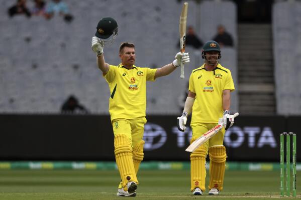 Australia's David Warner, left, is watched by teammate Travis Head, as he celebrates making 100 runs against England during their one-day international cricket match at the Melbourne Cricket Ground in Melbourne, Australia, Tuesday, Nov. 22, 2022. (AP Photo/Asanka Brendon Ratnayake)