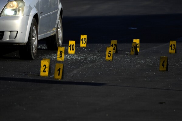 FILE - Evidence markers indicate the location of bullet casings at a crime scene where police say a fellow officer was fatally shot by cartel gunmen, in Celaya, Mexico, Feb. 28, 2024. At least 34 police officers have been killed in this city of 500,000 in the last three years. (AP Photo/Fernando Llano, File)