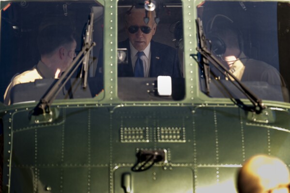 President Joe Biden speaks to pilots aboard Marine One as he arrives at the Wall Street Landing Zone in New York, Wednesday, Feb. 7, 2024, to attend fundraisers. (AP Photo/Andrew Harnik)