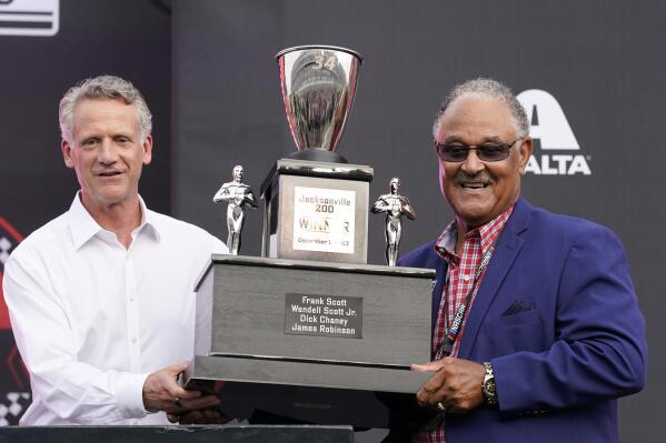 NASCAR President Steve Phelps, left, presents a trophy to Wendell Scott's son Frank Scott before the Cup Series auto race at Daytona International Speedway, Saturday, Aug. 28, 2021, in Daytona Beach, Fla. NASCAR presented Scott's family a custom trophy commemorating his historic 1963 victory. Scott was the first and remains the only Black driver to win a race at NASCAR's top level. (AP Photo/John Raoux)