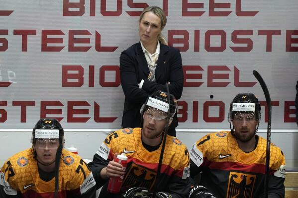 FILE - Germany's assistant coach Jessica Campbell stands behind players on the German bench during the group A Hockey World Championship match between France and Germany in Helsinki, Finland, Monday May 16, 2022. The Coachella Valley Firebirds have hired Jessica Campbell as the American Hockey League’s first female assistant coach. (AP Photo/Martin Meissner, File)