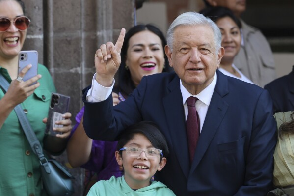 Outgoing President Andrés Manuel López Obrador poses for photos with supporters after voting in the general elections, in Mexico City, Sunday, June 2, 2024. (AP Photo/Ginnette Riquelme)