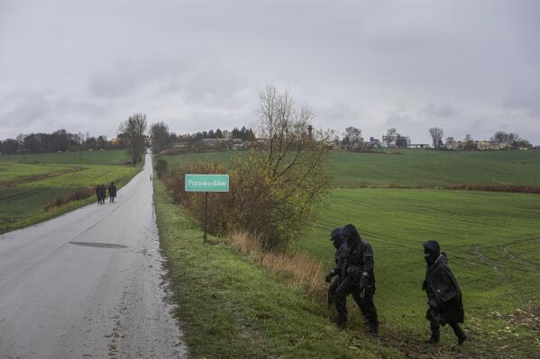 Polish police officers search for missile wreckage in the field, near the place where a missile struck, killing two people in a farmland at the Polish village of Przewodow, near the border with Ukraine, Wednesday, Nov. 16, 2022. (AP Photo/Evgeniy Maloletka)