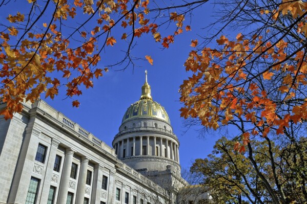 FILE - This Nov. 3, 2014 file photo shows the West Virginia Capitol with its dome framed by turning sugar maples leaves in Charleston, W.Va. West Virginia's unemployed workers will need to do more to prove they are searching for jobs to collect state benefits under a new law that will take effect next year. (Tom Hindman/Charleston Gazette-Mail via AP, File)