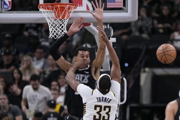 San Antonio Spurs center Victor Wembanyama is hit in the face as he blocks Indiana Pacers center Myles Turner (33) during the first half of an NBA basketball game in San Antonio, Sunday, March 3, 2024. (AP Photo/Eric Gay)